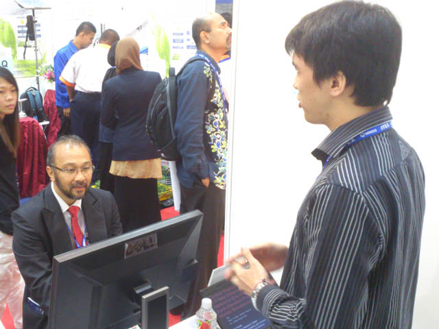 Gan (right) manning his booth in ITEX 2013