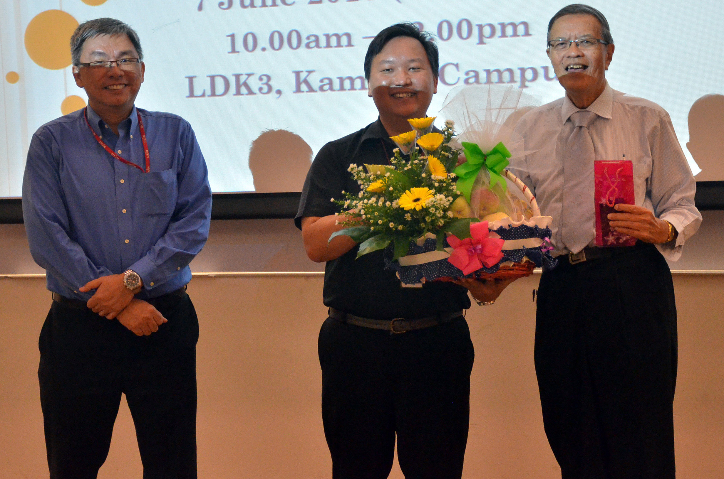 Tan (middle) presenting a token of appreciation to Prof Chan, while Ching (left) looks on